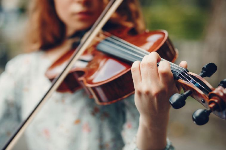 Menina bonita em parque com violino